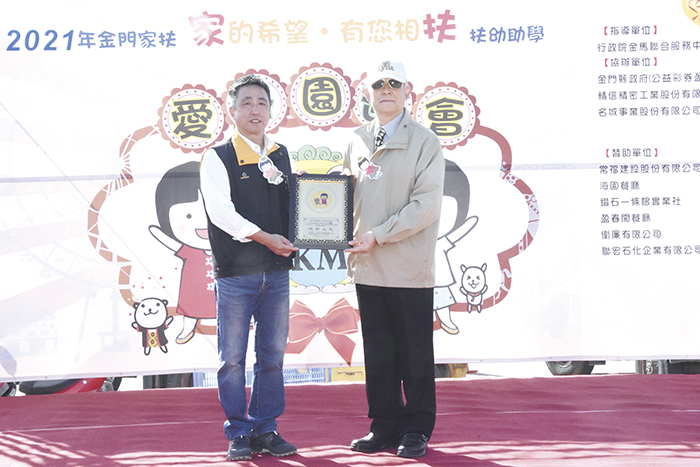 金門家扶中心扶幼主委李根遠,頒贈卅五年助養人感謝牌與榮耀給許金象,表彰其長年關懷弱勢兒童的捐助義行。(莊煥寧攝)