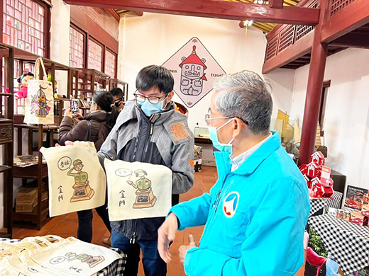 總兵小舖陳列展售由縣內年輕創作者製作的紀念商品,開幕當天副縣長李增財聆聽創作者的創作構想。(詹宗翰攝)
