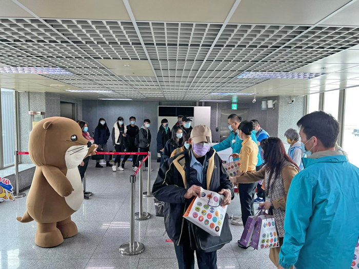金門縣觀光處與觀光大使阿特迎接搭著虎航彩繪機到來的旅客,贈送他們精心準備的小禮物。(詹宗翰攝)