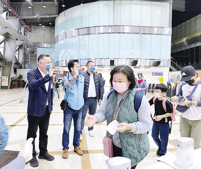 楊鎮浯縣長（左）在高雄機場和開心報到的旅客打招呼。（縣府觀光處提供）