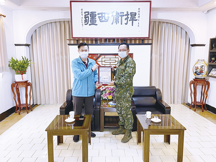 金門縣消防局陳叁奇大隊長代表局長王世祿致贈感謝狀給烈嶼守備隊大隊長高明弘。(消防局提供)