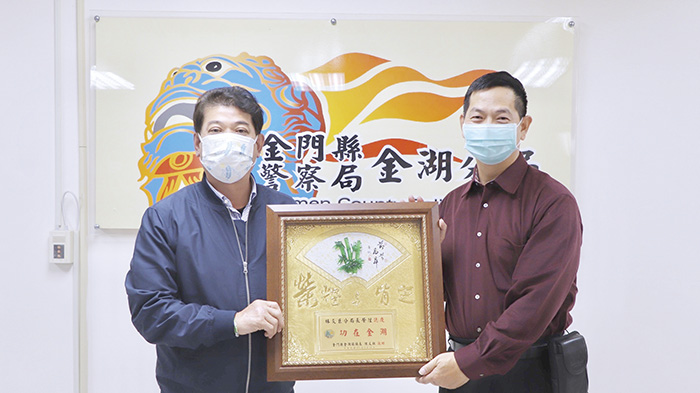 金湖鎮長陳文顧致贈「功在金湖」獎牌給即將卸任的金湖分局長林炎巨(右)。(金湖鎮公所提供)