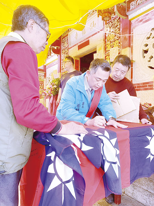 縣長楊鎮浯於國旗上簽名留念,該國旗將寄予愛國思鄉的旅外鄉親。(林靈攝)