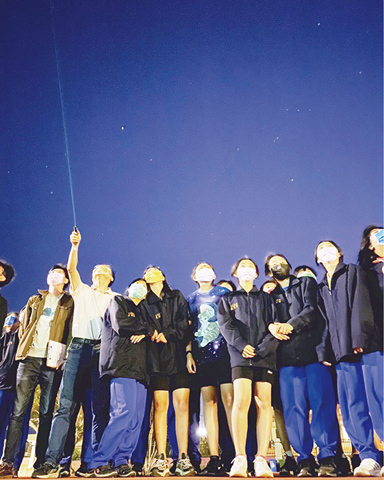 沙中學子在陳盈霖（圖中解說者）等老師介紹下，仰望星空、認識星座，學生不禁嘆道，原來天空這麼美。（金沙國中提供）