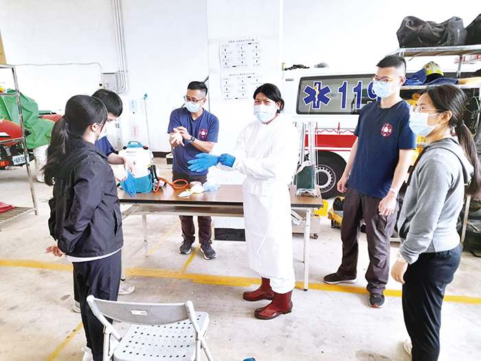 疫情嚴峻,金門縣消防局積極協調國軍,研擬支援救護車腹案、整合救護車資源,昨日辦理「隔離衣穿脫暨救護車出勤清消」訓練。(縣消防局提供)