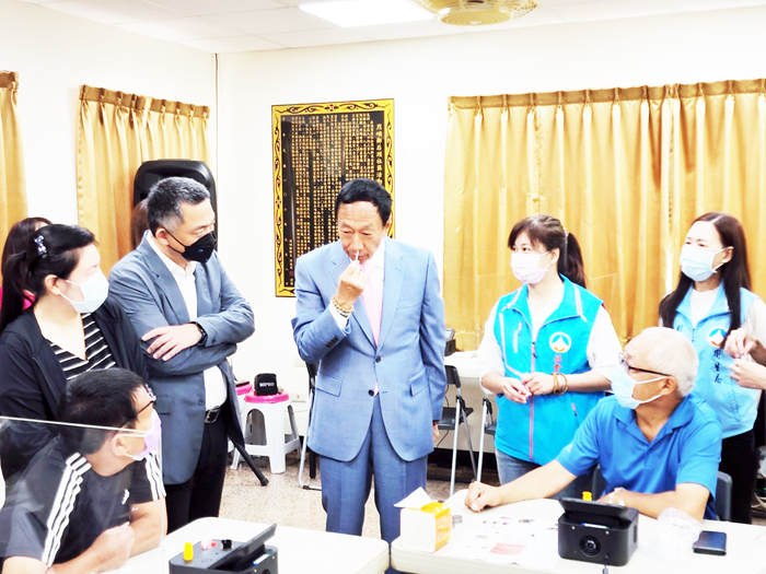 永齡基金會創辦人郭台銘(右3)親自示範如何使用家用PCR檢測儀。(許峻魁攝)