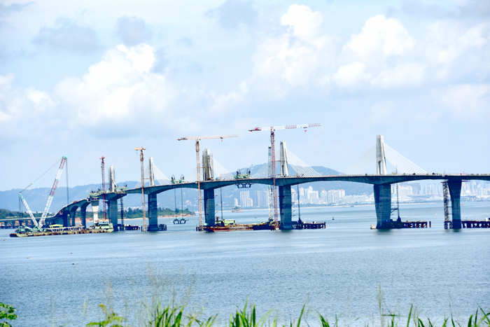 交通部王國材部長抵金視察金門大橋施工,並與縣長楊鎮浯、立法委員陳玉珍等人一起見證大橋預鑄節塊閉合塊的吊裝作業,慰勉工程團隊辛勞,也期勉積極趲趕工進,完成全線合龍及今年10月通車目標。(莊煥寧攝)