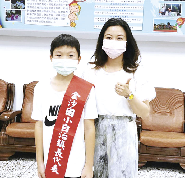 學子實際參與投票及開票等作業,最後由五年乙班吳英俊(左)、黃琪恩當選正、副鎮長,24日舉行交接典禮,校長李盈潔頒發當選證書及披掛彩帶。(金沙國小提供)