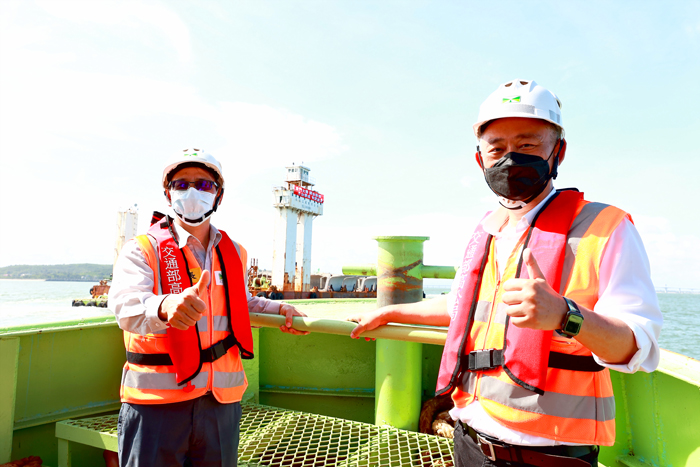 縣長楊鎮浯(右)、高公局第二新建工程處長郭呈彰(左)以預鑄節塊運輸船為背景合影。(許峻魁攝)