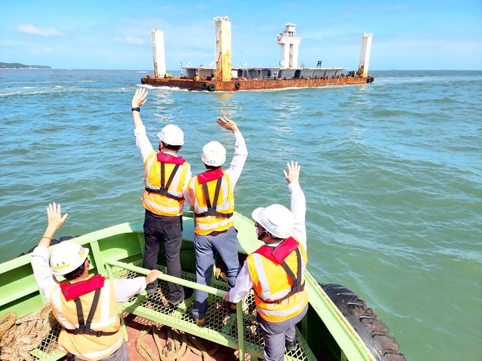 縣長與工程團隊於工程船上向節塊運輸船工作人員揮手致意。（許峻魁攝）