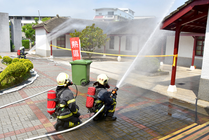 消防員灑水降溫滅火。（陳冠霖攝）