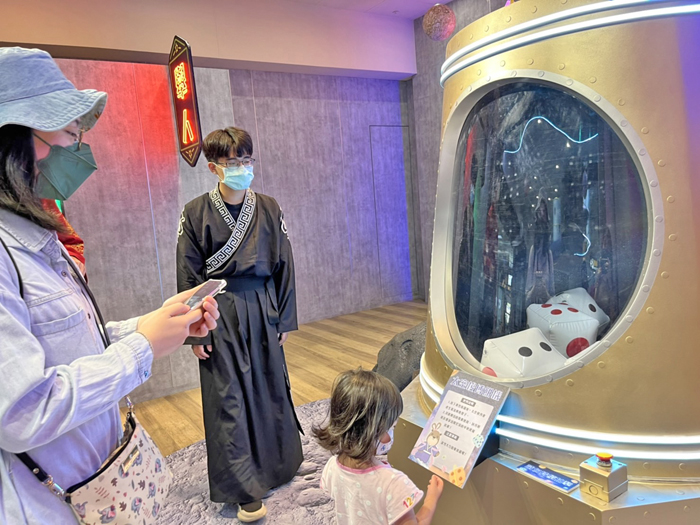 太空梭博餅機,遊客按鈕啟動骰子漂浮滾動,讓博餅充滿科技感。(觀光處提供)