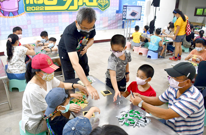 黃彥智教導小朋友拼出微笑碉堡。(楊水詠攝)