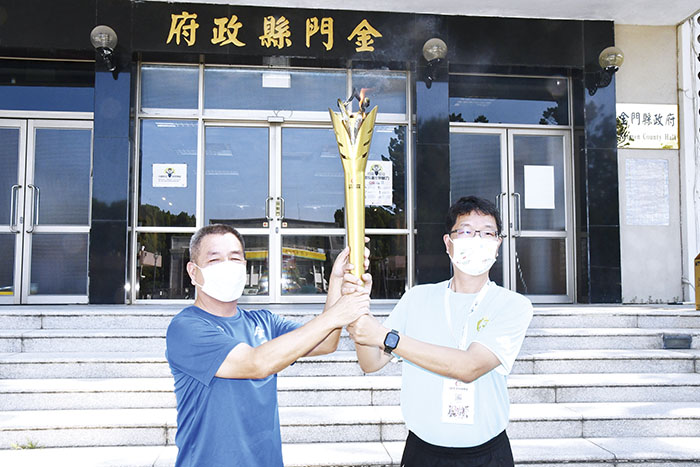 一一一年全民運動會聖火昨傳遞抵金門,並完成交接後展開各鄉鎮繞行活動,秘書長陳祥麟接引聖火。(楊水詠攝)