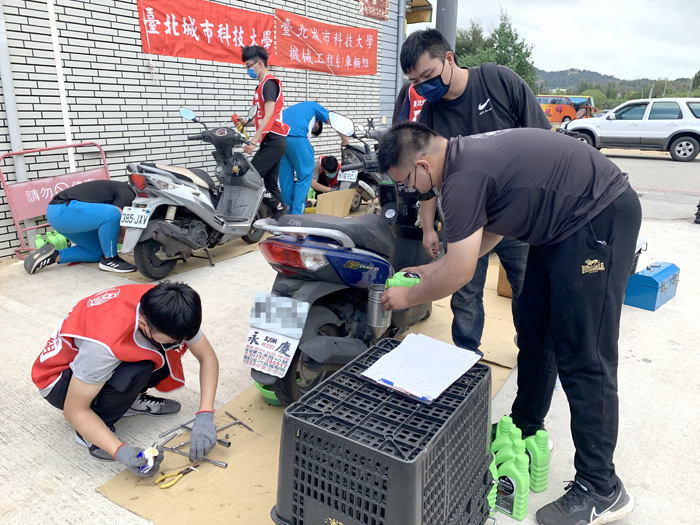 金門農工與台北城市科技大學共組「機車修護服務隊」,免費為地區民眾更換機油、齒輪油、機車除鏽、碟盤清潔等。(林靈攝)