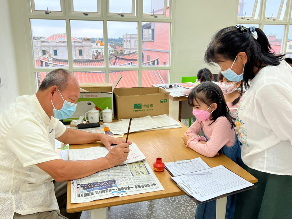 金沙圖書館「石獅爺陪伴閱讀小學堂」開辦書法初級班，邀請金門縣書法學會前任理事長吳宗陵到場指導，帶領學童循序漸進提筆寫字。（金沙圖書館提供）