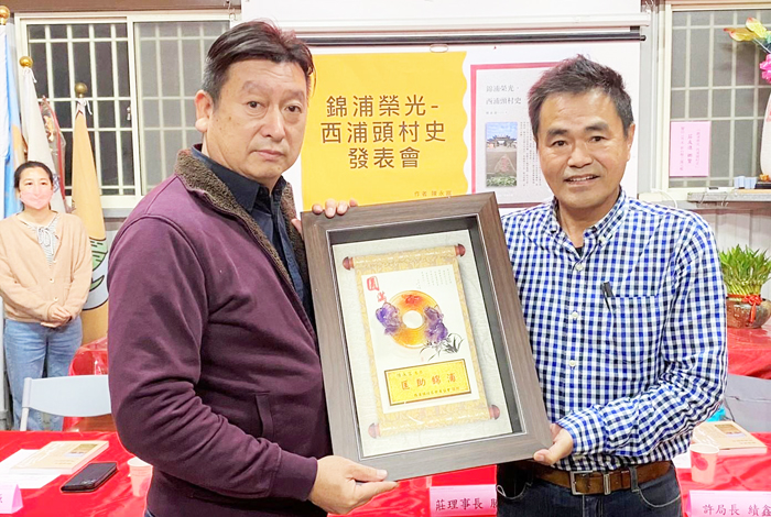 《錦浦榮光‧西浦頭村史》新書村莊分享會昨舉辦，西浦頭社區發展協會理事長莊勝騏贈送感謝匾給作者陳永富，且西浦頭村民熱烈參與活動。（西浦頭社區發展協會提供）