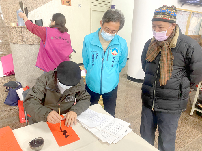 兔年手寫春聯大放送活動，昨在金門縣書法學會理事長徐心富（圖右）帶領下，熱鬧在文化局一樓大廳進行，文化局長許績鑫（圖中）也到場和大家同霑農曆年節即將到來的喜氣。（翁維智攝）