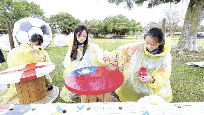 農曆新年即將到來，林務所於森林公園內規劃包子兔足球世界盃與足球場佈置，20位多年國小師生用回收電纜盤彩繪卡達世足賽前八強的國旗。（陳麗妤攝）