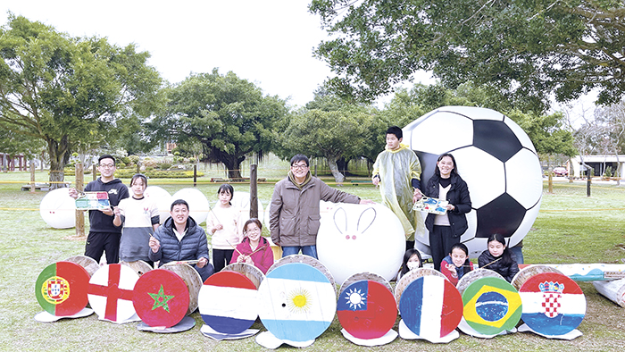 農曆新年即將到來，林務所於森林公園內規劃包子兔足球世界盃與足球場佈置，20位多年國小師生用回收電纜盤彩繪卡達世足賽前八強的國旗。（陳麗妤攝）