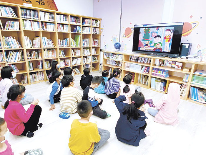 考量低年級學生的閱讀能力，閱讀方式以播放書籍動畫欣賞。（金鼎國小提供）