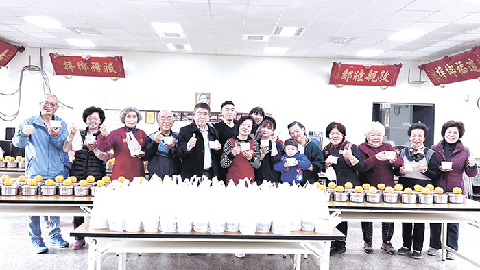 阿公ㄟ手手工豆花技術長許翼翔夫婦分送熱仙草餐點給金門城關懷據點參與供餐長輩,並與金門城社區理事長林孫全、志工隊長和長輩共同合影。(金門城關懷據點提供)