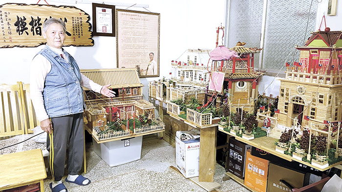 洪國華用一根根免洗筷,黏出一件件金門特色建築。(許峻魁攝)