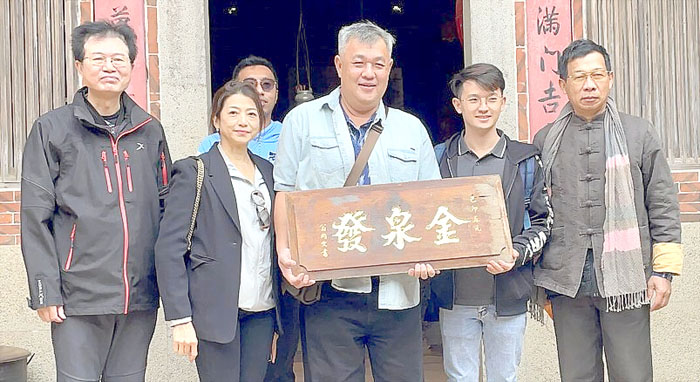 吳友鏗昨日攜帶先祖在南洋發跡的「金泉發」商號牌匾回到吳心泉宅，並放在供桌前，告慰先祖。（金門縣文化局提供）