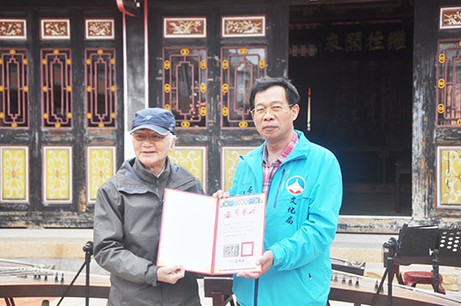 金門縣文化局局長呂坤和(右)致贈榮譽狀予金門文藝創刊人陳長慶(左),感謝他和金門文藝編輯群等對金門文學、文藝的貢獻。(李增汪攝)