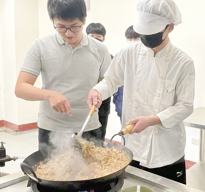 金門農工水產養殖科，不只養魚也會料理。學生在養殖科老師帶領下，在「水產料理實務」課程中，以自行養殖之塘虱魚，料理生產新實習產品─香辣魚醬罐頭。（陳麗妤攝）