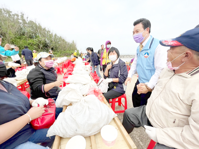 縣長陳福海與千人剝蚵的參與者寒暄；副縣長李文良等人由蚵田挑石蚵，為千人剝蚵揭序曲。（高凡淳攝）