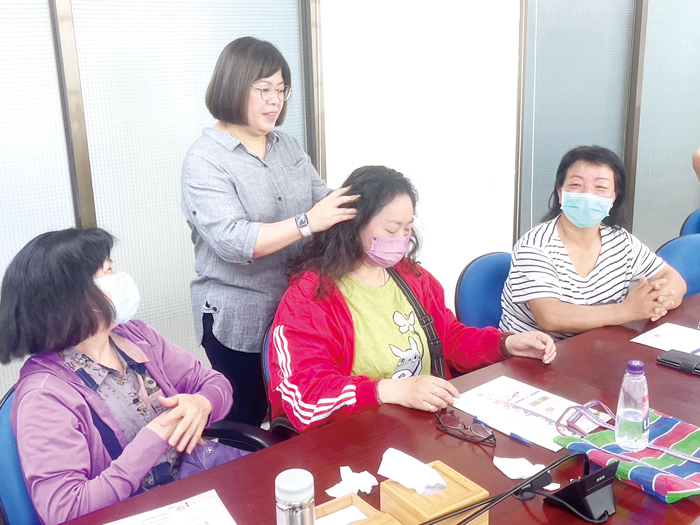 講師指導學員利用精油進行頭部按摩。(移民署金門服務站提供)