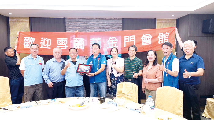 台北市金門同鄉會理事長許奮鬥(左5)致贈紀念品給馬來西亞雪蘭莪金門會館主席陳良吉(左4)。(許木進提供)