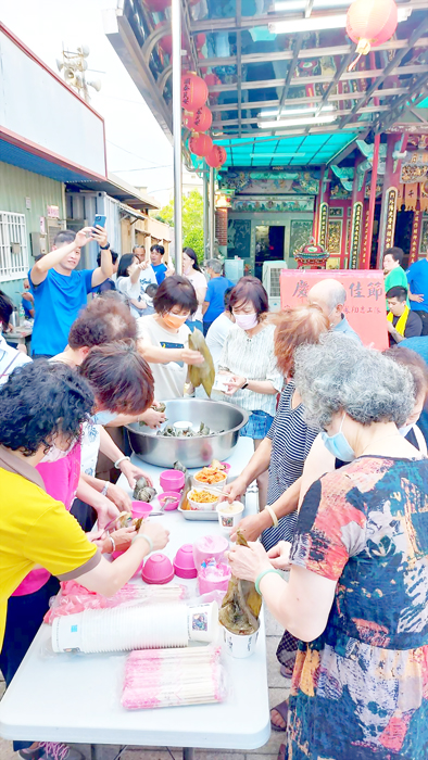 在管委會主委許丕祺和志工隊長董雅萍熱情號召下，宏德宮管理委員會昨聯手鳳翔志工隊舉辦包粽活動。（翁維智攝）