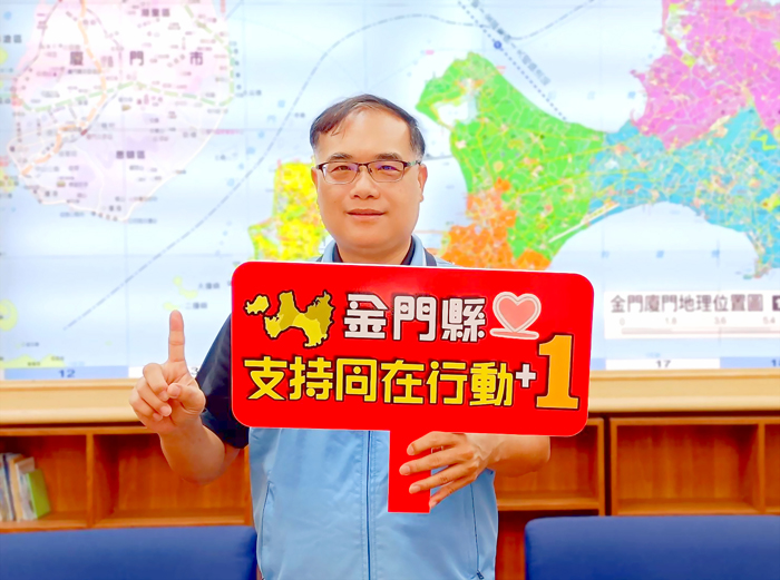 副縣長李文良手持「金門縣支持同在行動＋1」字牌，響應「失智友善，社會共伴」倡議活動。（衛生局提供）