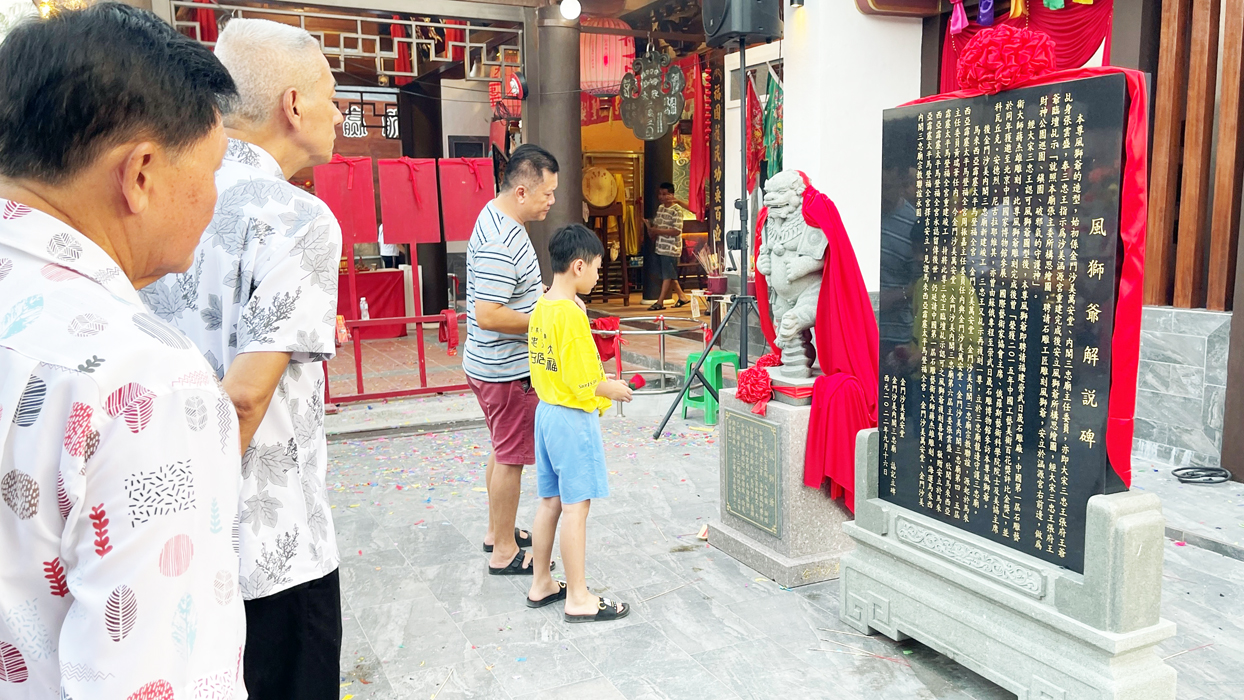 由萬安堂三忠廟所贈的風獅爺及解說牌，在與會貴賓揭牌及法師與眾王爺主持下完成開光儀式，吸引當地民眾駐足欣賞。（陳麗妤攝）