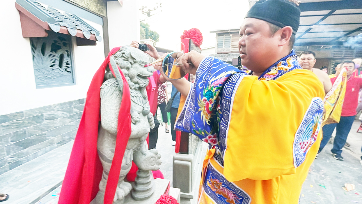 由萬安堂三忠廟所贈的風獅爺及解說牌，在與會貴賓揭牌及法師與眾王爺主持下完成開光儀式，吸引當地民眾駐足欣賞。（陳麗妤攝）