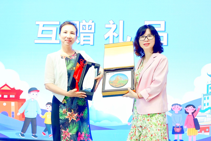 雙方互贈金門高粱酒及「惠和影雕」象徵友誼長長久久。（金門縣婦女會提供）