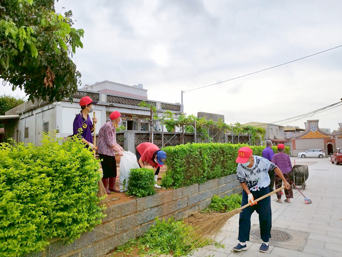 社區清潔日碰上颱風來襲，居民認真清理居住環境周遭，並為防颱做準備。（金城鎮公所提供）