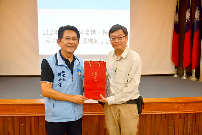 縣府秘書長謝世傑代表縣長致贈工程會主任秘書羅天健金門禮品。（楊水詠攝）