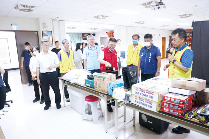 訪視委員們來到古寧頭社區活動中心檢視避難收容場所，由社區總幹事李俊龍（右）解說導覽收容所設施。（金寧鄉公所提供）