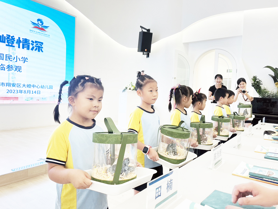 金湖國小楊偉彣主任為大嶝幼兒園幼童解說湖幼學童的作品。(金湖國小提供)