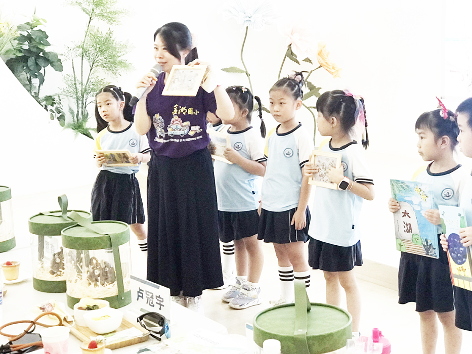 金湖國小楊偉彣主任為大嶝幼兒園幼童解說湖幼學童的作品。(金湖國小提供)