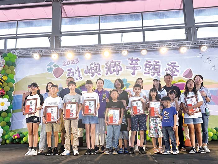 芋頭季徵圖比賽的績優作品學生和家長,開心接受烈嶼鄉長洪若珊頒獎獎勵。(高凡淳攝)