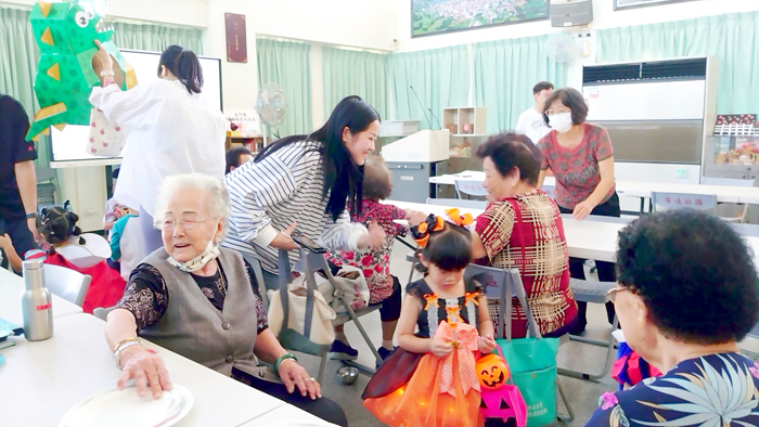 幼兒園孩子與社區長輩互動要糖，模樣相當可愛。  （上岐國小提供）