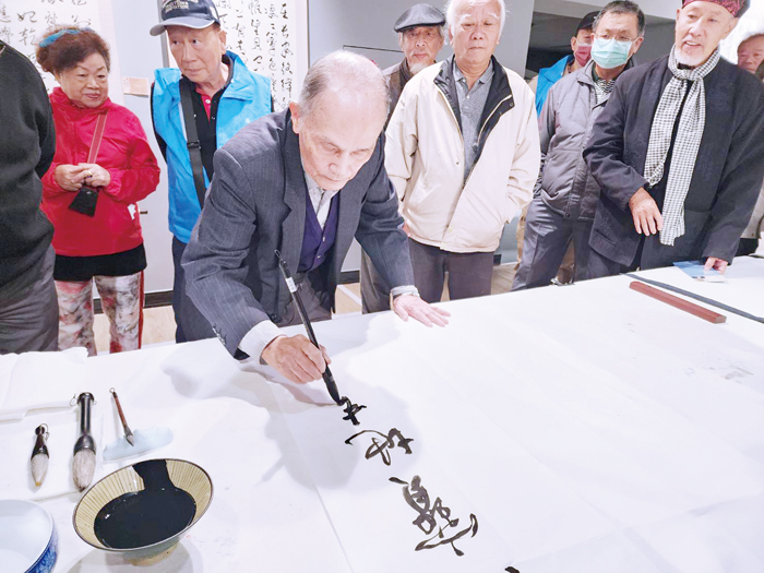 高齡八十八歲的書法名家蔣夢龍揮毫。（許峻魁攝）