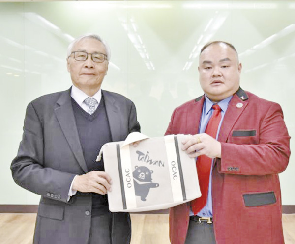 張良民(左)與僑務促進委員陳為寶(右)贈僑委會紀念品。(圖源:陳雯雯提供)