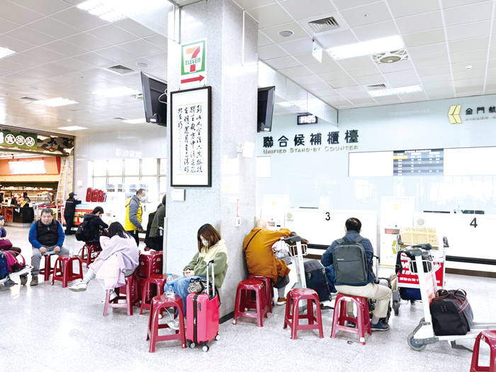 台金航線幾乎班班客滿，坐在候補櫃檯前的旅客一票難求。（高凡淳攝）