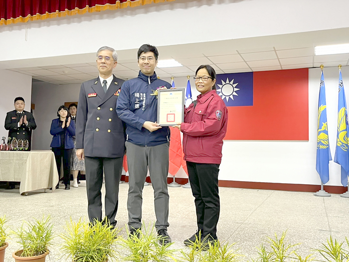 楊上德執行長頒發內政部業務志願服務獎章證書,授獎人為義消第三大隊大隊長張翠敏。(高凡淳攝)