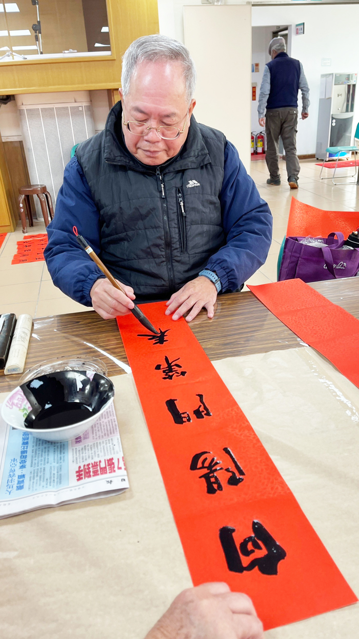 金沙鎮公所「迎新春.寫春聯」,書法學會理事長徐心富等十餘位地區書法家到場揮毫。(陳麗妤攝)